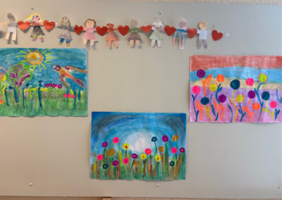 Selbstgemalte Blumenbilder der Kunst-AG hängen an einer Wand der Grundschule Neuennaus.