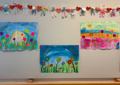 Selbstgemalte Blumenbilder der Kunst-AG hängen an der Wand der Grundschule Neuennaus.