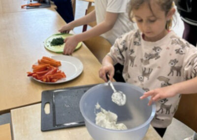 Kinder bereiten Rohkost und einen Dip zu.